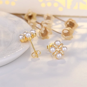 Elegant gold flower stud earrings featuring white pearls and sparkling cubic zirconia crystals