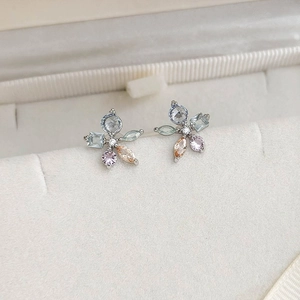 Macro shot of zircon flower earrings with multi-color gemstones in a leather jewelry box