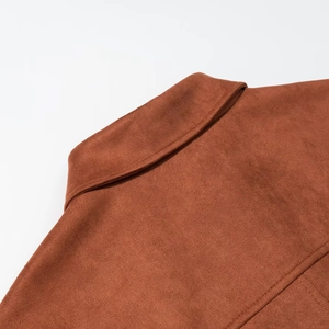 Detailed close-up of brown suede fabric texture and stitching on the collar and back