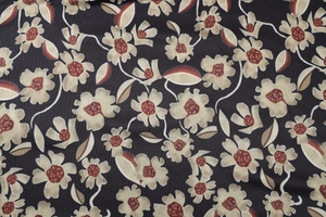 Detailed view of floral print fabric in beige and reddish-brown on dark base
