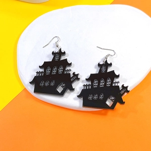 Detailed close-up of Halloween black acrylic haunted house drop earring on white tray
