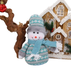 Süßer blau-weißer Plüsch-Schneemann mit Strickmütze auf festlichem Holz-Hintergrund