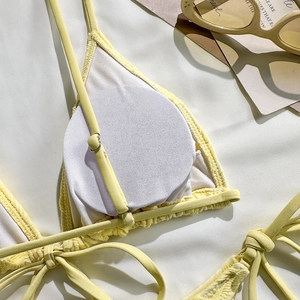 Close-up of yellow bikini top featuring waffle texture fabric and silver metal buckles