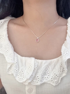 Nahaufnahme eines rosa Chalzedon-Anhängers an einer Sterlingsilber-Halskette am Model