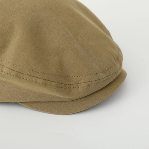 Detailed close-up of khaki cotton fabric texture and precise stitching on children's beret
