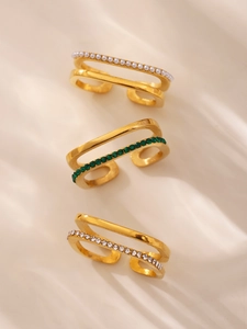 Detail view of double-layered gold-plated rings with pearls and green cubic zirconia