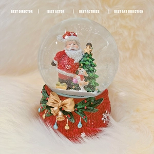Christmas musical snow globe with Santa and dog on a red knit-textured base with golden bow
