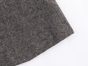 Detailed macro view of heavy herringbone wool fabric texture on a fashion blazer