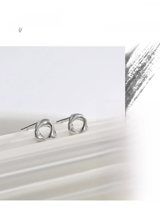 Macro detail of high-quality silver twisted geometric earrings with polished metal finish