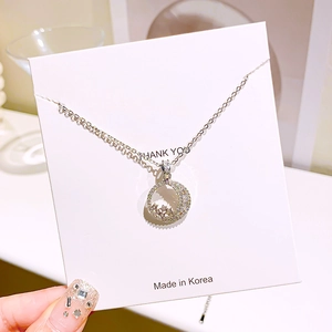 Macro shot of silver moon and star pendant with sparkling cubic zirconia on necklace