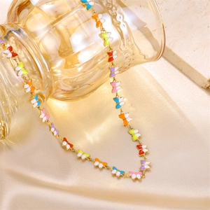 Detailed macro view of colorful enamel butterfly pendants on a dainty gold-toned chain