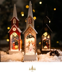 Close-up of lighted Nativity Christmas church lanterns with falling snow and warm LED glow