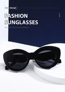 Detail view of glossy black cat-eye sunglasses on a white pedestal with sharp lighting