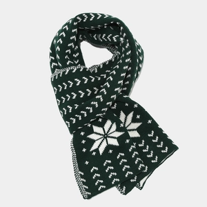 Detail of green knit scarf with white snowflake patterns and geometric nordic texture