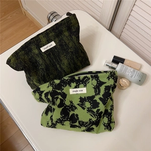 Detailed close-up of moss green and floral canvas makeup bags with zip closure