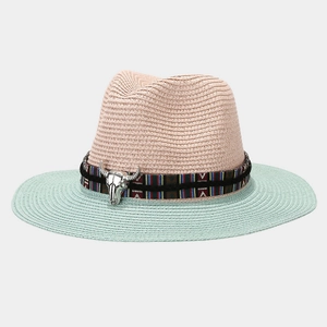 Detail of bohemian straw hat featuring mint green brim and silver bull head ornament