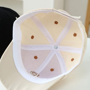 Detail view of cotton baseball cap interior showing white stitching and breathable eyelets