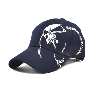 Detailed close-up of white skull embroidery on navy blue cotton baseball cap