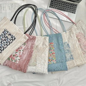 Flat lay of colorful lace and velvet tote bags with floral embroidery on desk