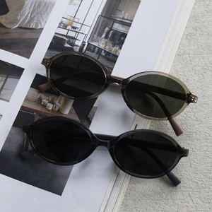 Flat lay of oval polarized sunglasses in tortoiseshell and black on a magazine