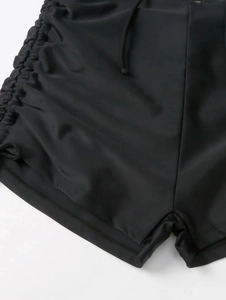 Detail of black bikini bottoms with side ruched drawstring and quick-dry textured fabric