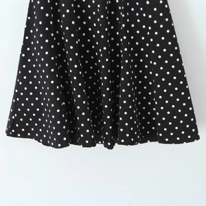 Robe dos nu à pois noirs avec décolleté plongeant en V et coupe ajustée sexy