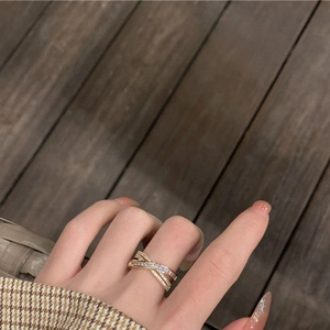 Détail d'une bague croisée dorée sertie de zircons brillants au style chic