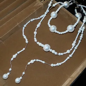 Elegant multi-layer white pearl necklace set displayed in a premium brown velvet jewelry box