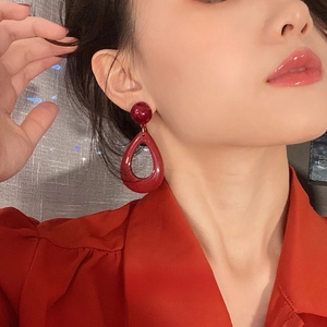 Elegant vintage resin red drop earrings for women with silver needle stud on a model