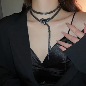 Choker-style snake tassel necklace with crystal accents and dark grey woven mesh chain