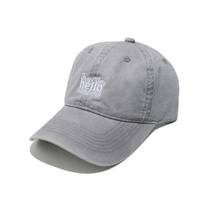 Close-up of white Hello embroidery on a grey washed cotton baseball cap with curved brim