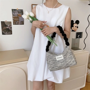 Vintage textured canvas tote bag with woven fabric and black pleated shoulder strap