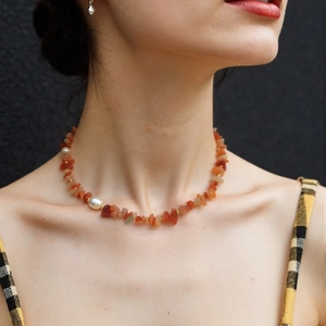 Detail of red agate and pearl necklace on model with vintage ethnic style elements