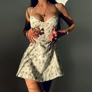 Detalle del vestido corto evasé con estampado floral y tirantes finos en una modelo