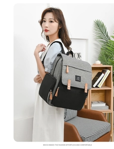 Detail of grey and black diaper backpack with multi-pockets shown on a model