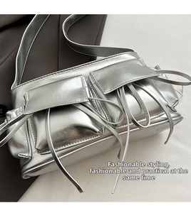 Detailed macro view of silver glossy PU leather crossbody bag with utility pockets