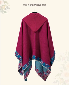 Detail of red hooded poncho with bohemian floral embroidery and white blanket stitch edge