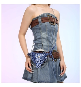 Macro detail of round denim crossbody bag with creative blue leopard bikini decor and metal ring
