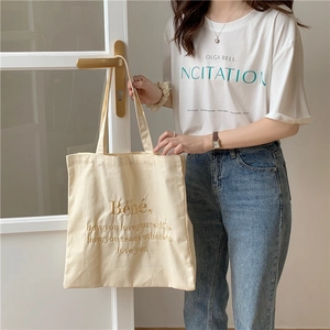 Detailaufnahme der Bébé Bestickung auf cremefarbenem Canvas-Shopper mit Stoffstruktur