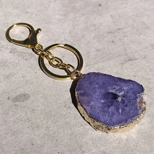 Detail of purple natural agate slice keychain with golden plated edge and lobster clasp