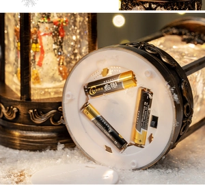 Detail of the vintage snow globe base showing battery compartment and power switch