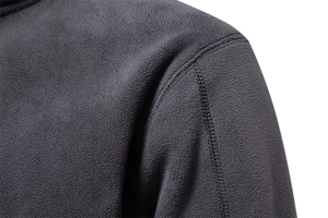 Macro detail of charcoal grey fleece fabric showing durable shoulder stitching on sweatshirt
