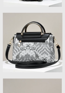 Detail view of the black and white wave pattern handbag with a gold-tone zipper back pocket