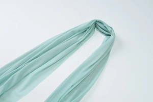 Detailed close-up of light mint green sequin fabric showing smooth texture and drape