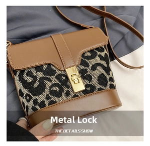 Detail of vintage bucket bag with leopard print stitching and golden twist lock