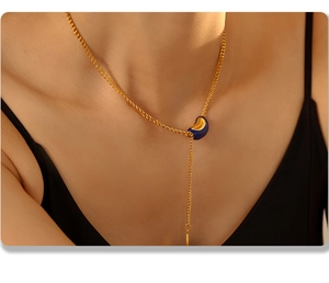 Close-up of elegant gold tassel necklace with blue and gold bean pendant on neck