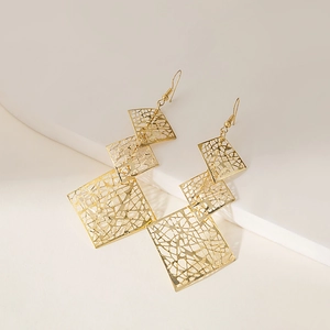 Detailed macro shot of triple-layered golden square drop earrings with textured hollow pattern