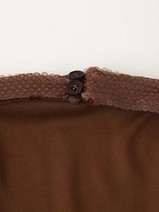 Macro shot of brown knit fabric with sparkling sequins and deep brown buttons detail