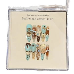 Blue and brown gradient press-on nails with 3D bears, bows, and pearls in a clear box
