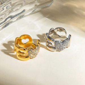 Détail d'une bague câlin en or et argent avec un cœur étincelant serti de strass